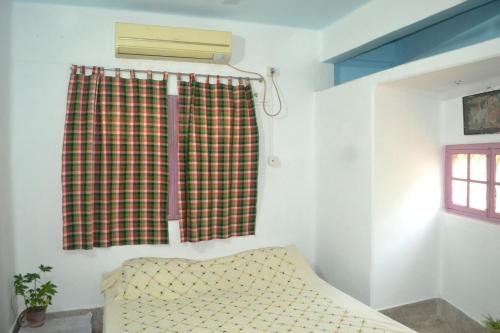 een kamer met een raam met een bank en airconditioning bij Gayitri in Calcutta
