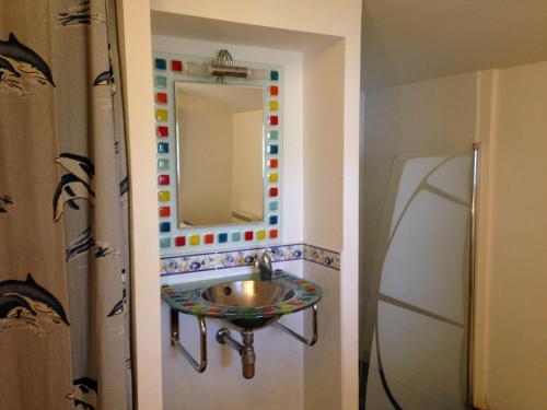 une salle de bain avec un lavabo et un miroir dans l'établissement Maison cosy entre vignes et plage, à Dolus-d'Oléron