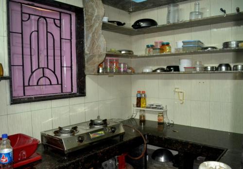 een keuken met een glas-in-loodraam aan de muur bij Gayitri in Calcutta