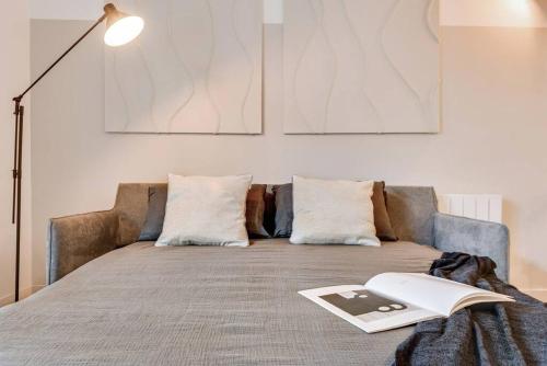 - un lit avec un livre dans l'établissement Monceau - 1 chambres à Batignolles, à Paris