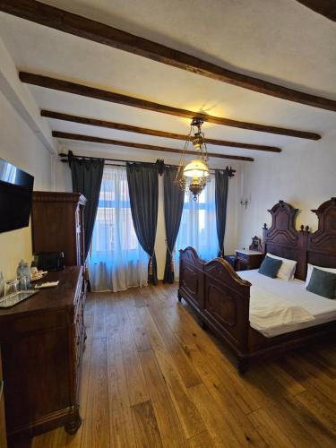 a large bedroom with two beds and a chandelier at The Throne - M Museum Hotel in Sighişoara