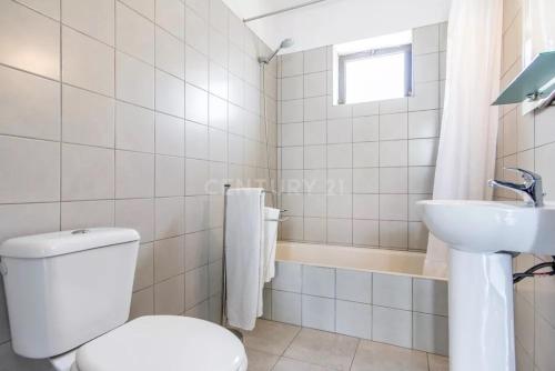 a white bathroom with a toilet and a sink at Villa Lucia, Olhos D'Agua, Albufeira in Albufeira