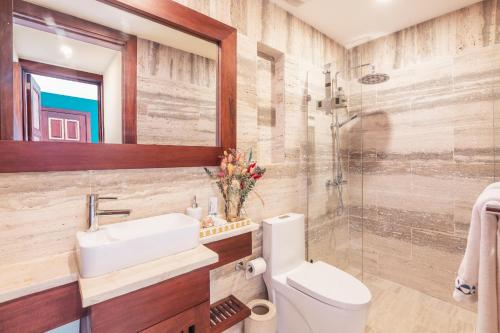 a bathroom with a sink toilet and a mirror at Comfortable and charming apartment at Portillo WF in Las Terrenas