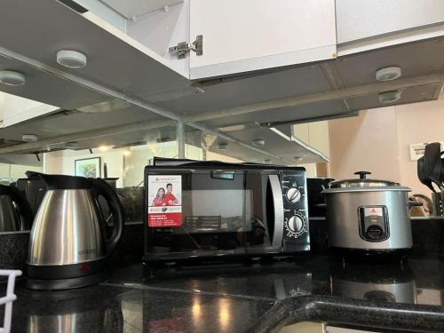 a microwave sitting on a counter in a kitchen at The Beacon Condo (1BR Unit) in Manila
