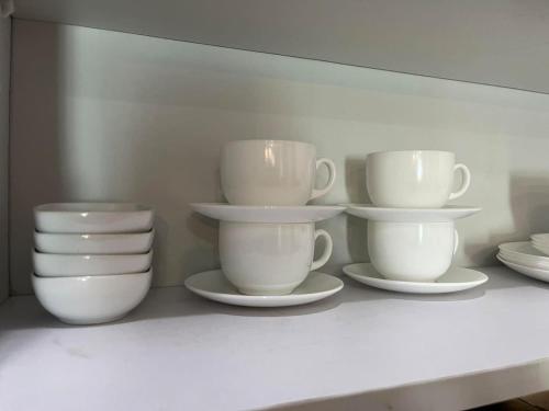 a shelf with white cups and plates on it at The Beacon Condo (1BR Unit) in Manila