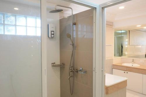 a bathroom with a shower with a glass door at Makati Altean Apartment (Delfin Room) in Manila