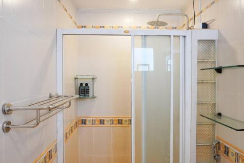 a shower with a glass door in a bathroom at Makati Altean Apartment (Leonora Room) in Manila