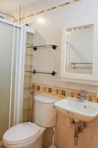 a bathroom with a toilet and a sink and a mirror at Makati Altean Apartment (Leonora Room) in Manila