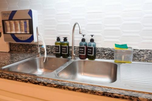 a kitchen sink with three bottles of wine at Makati Altean Apartment (Leonora Room) in Manila