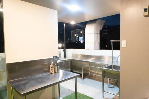 マニラにあるMaria Deck Urban Glampingのキッチン(テーブル2台付)、大きな窓が備わります。
