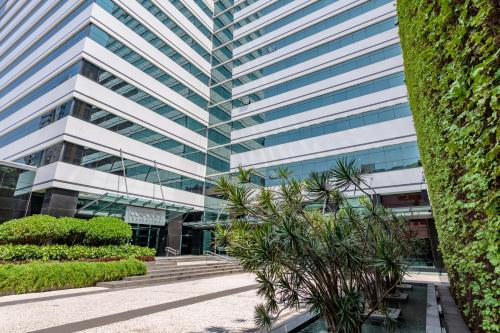 a tall building with trees in front of it at Pestana Curitiba in Curitiba