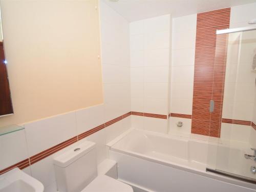 a white bathroom with a tub and a toilet at 2 Bed in Brixham HIGLI in Brixham