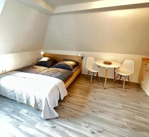 um quarto com uma cama, uma mesa e cadeiras em Ferienwohnung in Hürth bei Köln em Hürth
