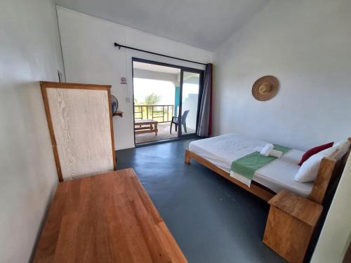 una camera con letto e porta di accesso a un balcone di Belle Etoile Océan a Rodrigues Island