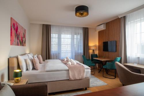 sypialnia z łóżkiem i salon w obiekcie Holdvirág Hotel w Sárvárze