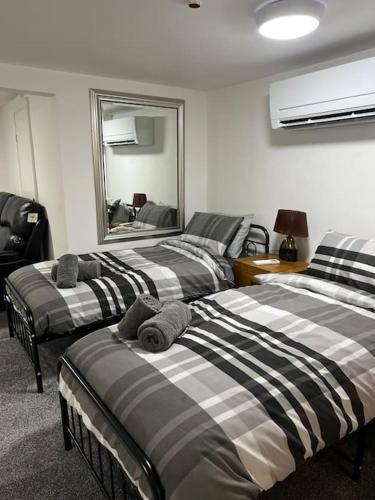 a room with three beds and a mirror at Studio Flat Twin - Town Centre in Merthyr Tydfil