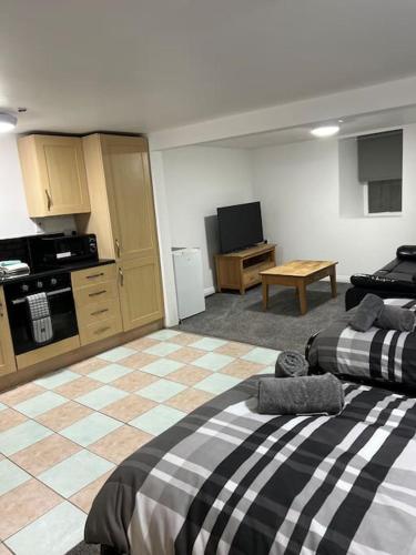 a living room with two beds and a kitchen at Studio Flat Twin - Town Centre in Merthyr Tydfil