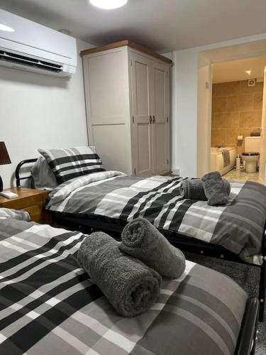 three beds in a room with towels on them at Studio Flat Twin - Town Centre in Merthyr Tydfil