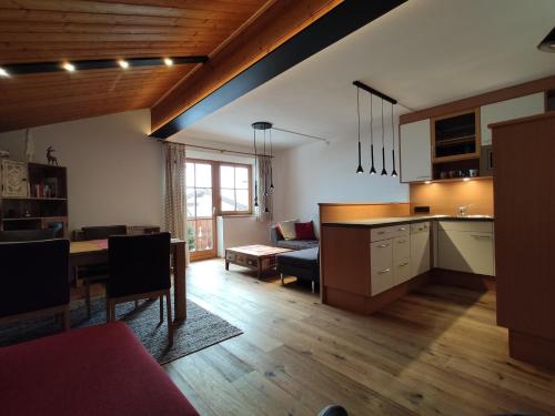 cocina y sala de estar con mesa y sofá en Sonnenbichl, en Berwang