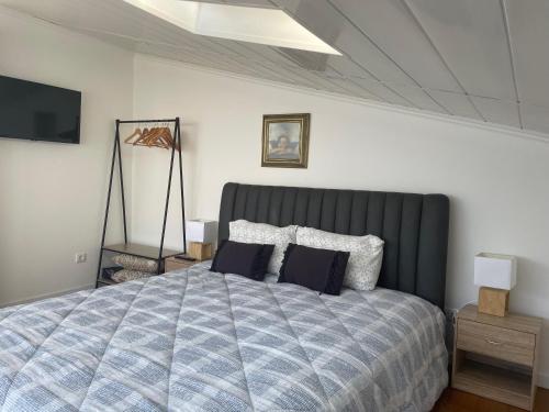 een slaapkamer met een groot bed met kussens erop bij Apartamento Deluxe II RB in Ribeira Brava