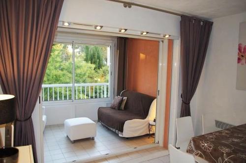 ein Wohnzimmer mit einem Sofa und einem Fenster in der Unterkunft 150 m plage, domaine privé avec piscine in Six-Fours-les-Plages