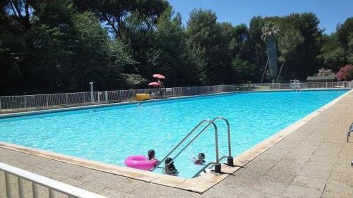 zwei Kinder in einem Pool mit einem rosa Schwimmer in der Unterkunft 150 m plage, domaine privé avec piscine in Six-Fours-les-Plages