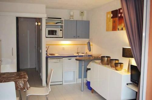 eine kleine Küche mit einer Theke und einem Tisch in der Unterkunft 150 m plage, domaine privé avec piscine in Six-Fours-les-Plages