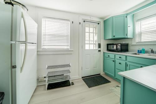 a kitchen with green cabinets and a refrigerator at Waterfront Chautauqua Lake Home with Stunning Views in Jamestown