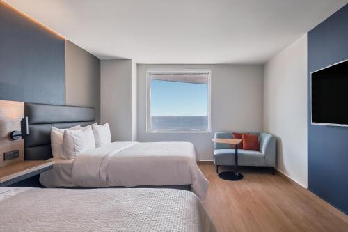 a hotel room with two beds and a television at Fiesta Inn Mazatlán in Mazatlán