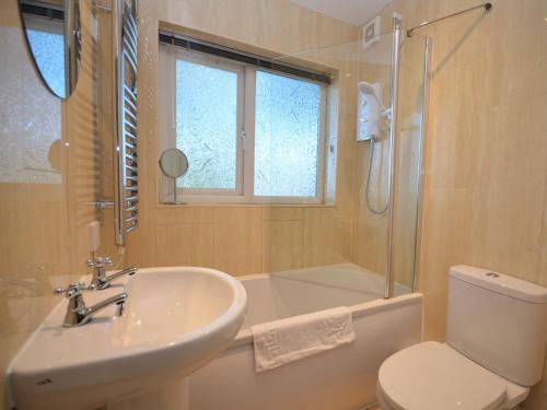 a bathroom with a sink and a toilet and a shower at 2 Bed in Brixham BX081 in Brixham
