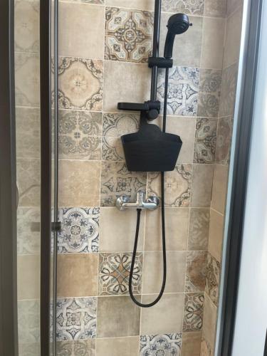 een douche met een douchekop in de badkamer bij Apartamento Deluxe II RB in Ribeira Brava
