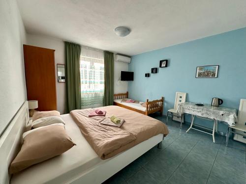 a bedroom with a large bed and a desk at Maki Apartments - Plavi Horizonti Beach in Tivat