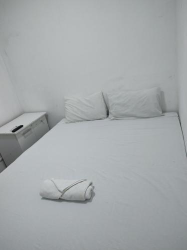 uma cama branca com um sapato em cima em Pousada Belo Mar em Salvador