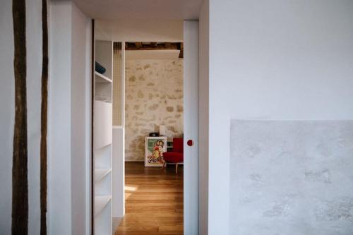 un couloir menant à un salon avec une chaise rouge dans l'établissement Charming Paris Hideaway, à Paris