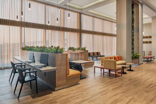 a lobby with a desk with a computer and chairs at Fiesta Inn Mazatlán in Mazatlán