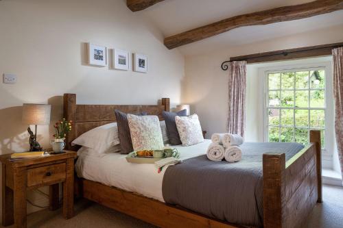a bedroom with a large bed with towels on it at Carrholme Cottage in Settle