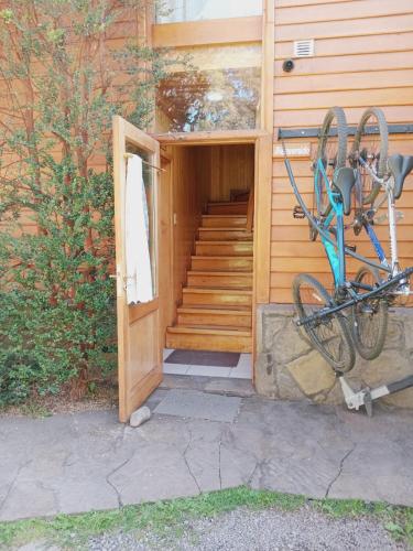 a bike parked outside of a building with a door at Apart Hotel del Pellin in San Martín de los Andes
