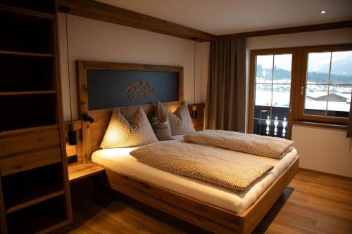 a bedroom with a large bed with a window at Pension-Appartement Sonnwend in Westendorf