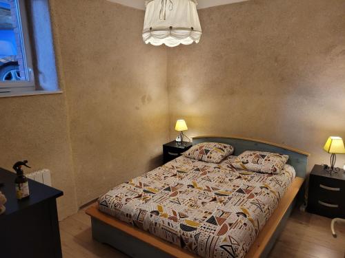 - une chambre avec un lit avec une couette et 2 lampes dans l'établissement Apparte Cosy Avec Terrasse Et Parking, à Dinan