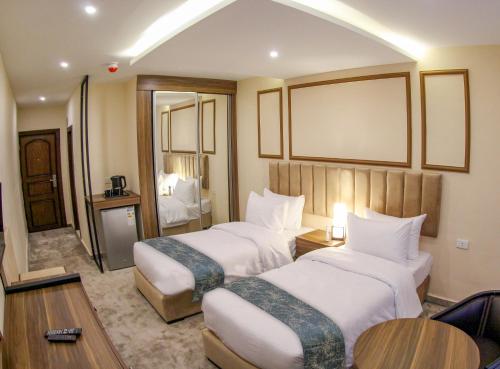a hotel room with two beds and a table at POST Hotel Amman in Amman