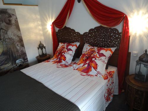 a bedroom with a bed with a red canopy at La Fontenelle Chambres d'Hôtes in Sainte-Sévère