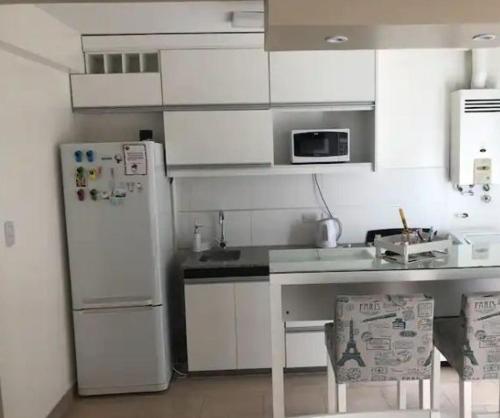 eine Küche mit weißen Schränken und einem weißen Kühlschrank in der Unterkunft DPTO FRENTE AL PARQUE FRANCISCO DE AGUIRRE in Santiago del Estero