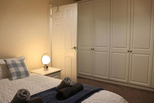 a bedroom with a bed with a blue blanket at Comfortable 2 Bedroom House in Beeston Hill