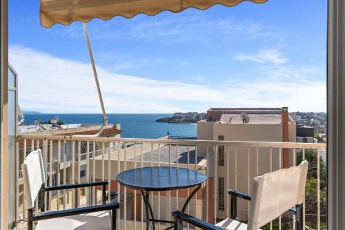 a balcony with a table and chairs and the ocean at On The Port: Studio in Rafina