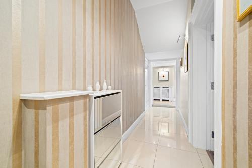 a hallway with a staircase with a striped wall at Central London Apartment in London