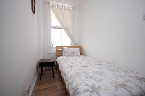 a small bedroom with a bed and a window at Lovely South Kensington Flat in London