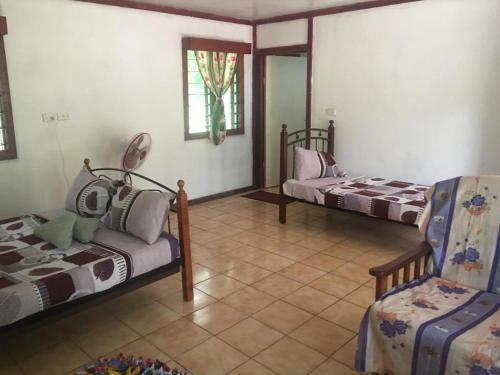 a living room with two beds and a chair at Long Beach Escape in Vuake