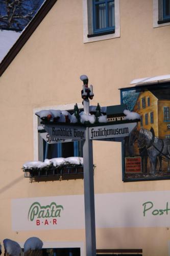 a street sign in front of a building at Hotel Erbgericht Buntes Haus in Seiffen