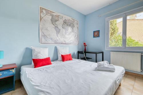 a bedroom with a large white bed with red pillows at élégante villa avec piscine privée près de cassis in Carnoux