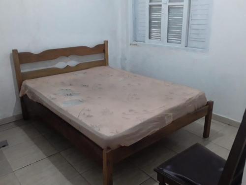 Pousada do Toninho في بيرويبي: سرير صغير في غرفة مع نافذة